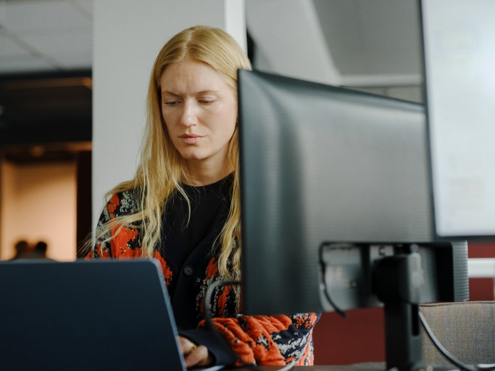 A teammate working at a window-lit desk