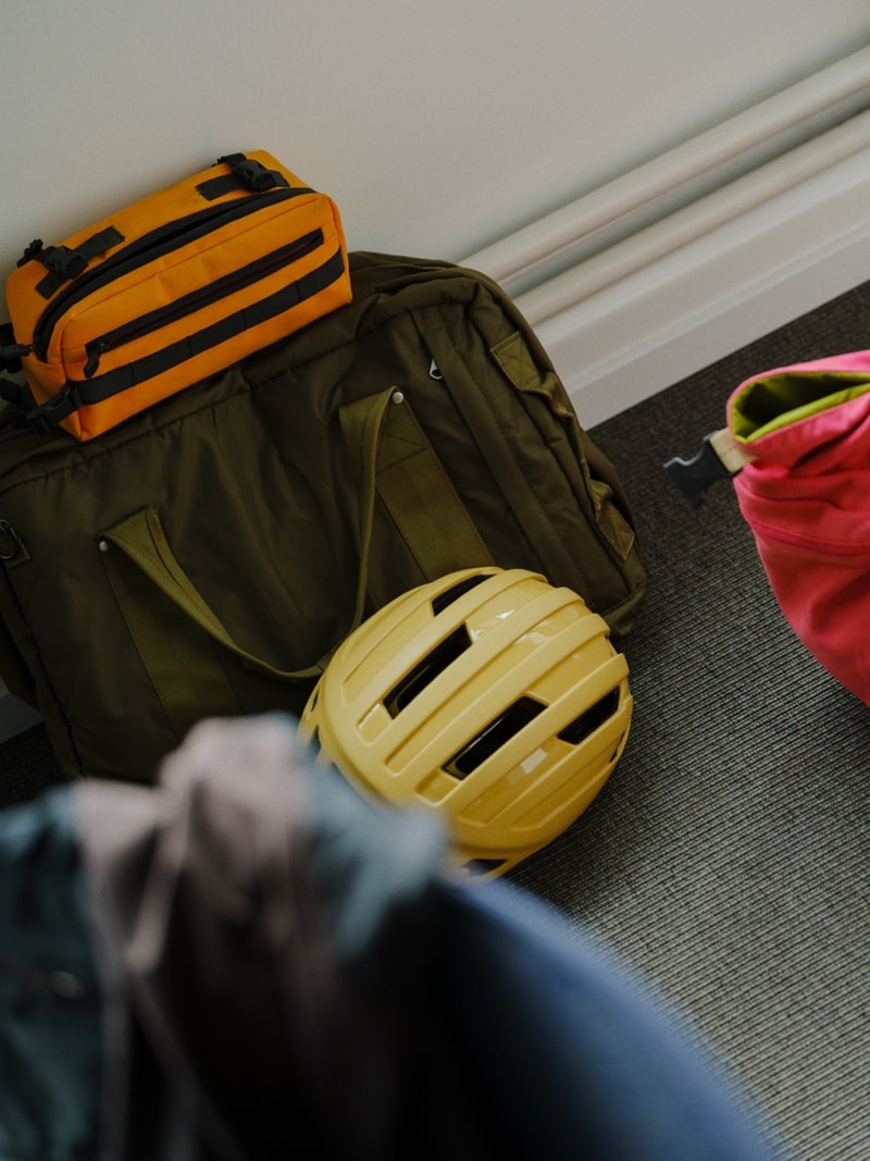 A bike helmet resting on a backpack by the office window