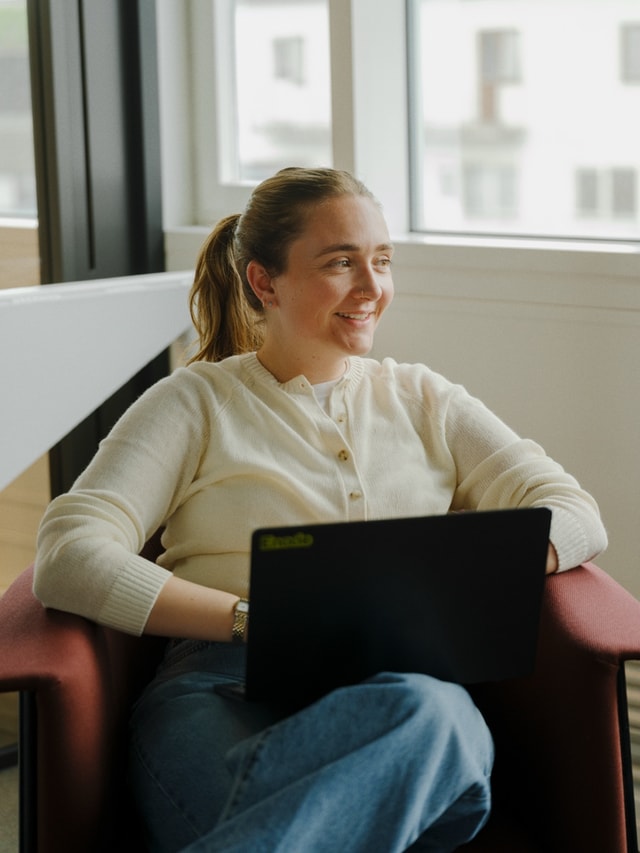 A teammate working from a lounge chair with a laptop