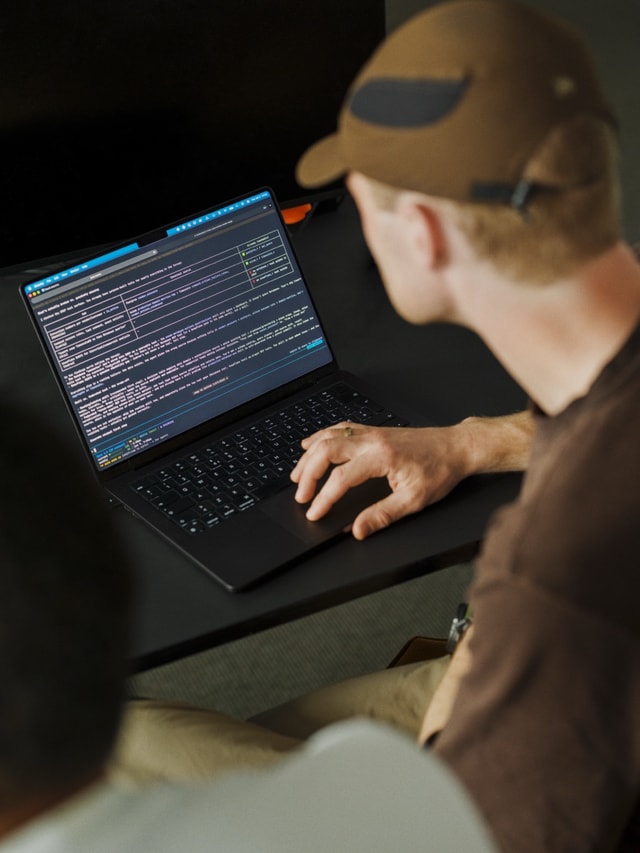A developer in a cap heads-down on code